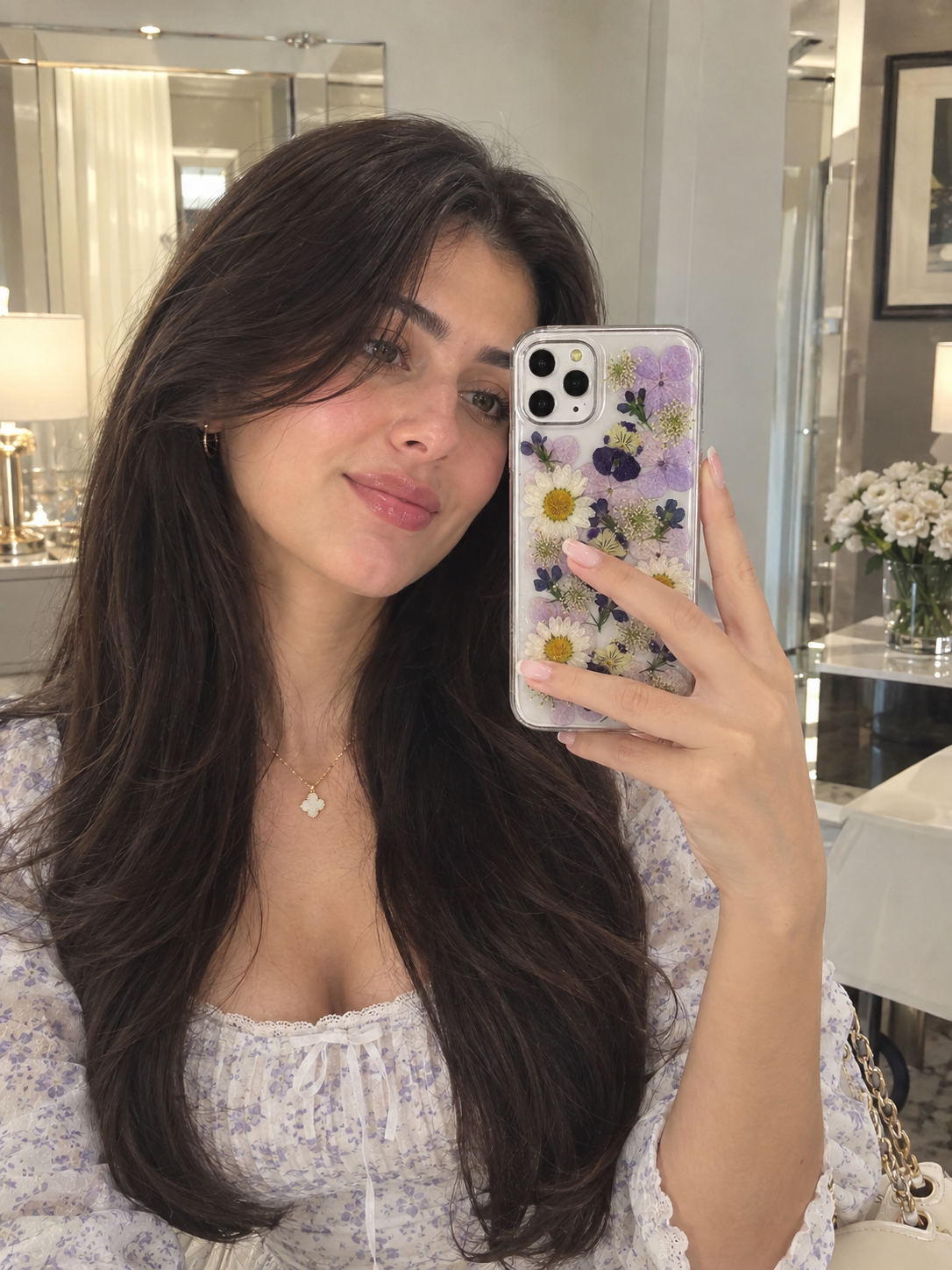 Clear iPhone case with preserved purple and yellow flower design, camera cutouts visible