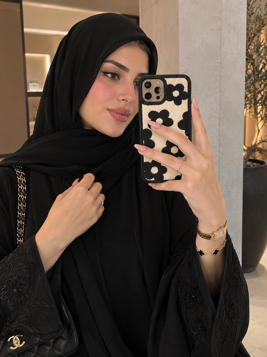 Floral iPhone case with black and light pattern, held in hand for a close-up view