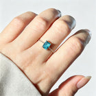 Adjustable micro-paved diamond ring with blue square gemstone worn on finger